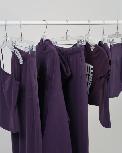 A clothing rack with matching dark purple items on it.
